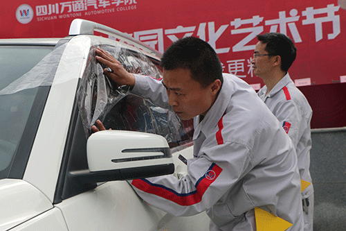學生在認真的為汽車貼膜